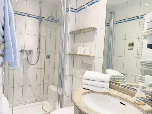 a bathroom with a shower and a sink at Seehotel Neue Liebe in Cuxhaven