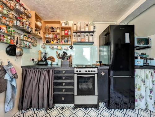 a kitchen with a stove and a refrigerator at Spacious Single Bed Room near Newhaven Town Centre in Tarring Neville
