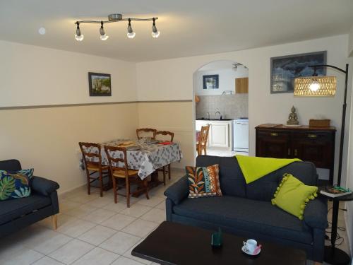 een woonkamer met twee banken en een tafel en een keuken bij La Pardigone in Castellane