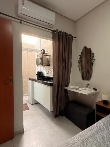 a small kitchen with a sink and a microwave at Pousada Minas Gerais in Araxá