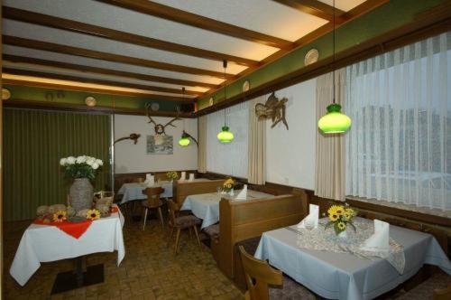 uma sala de jantar com duas mesas e cadeiras e luzes em Hotel Jägersruh em Monschau
