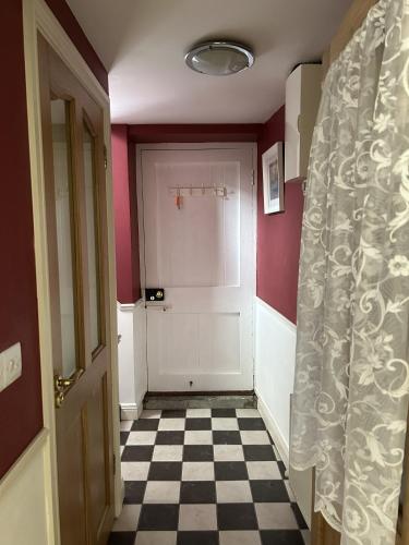 a hallway with a white door and a checkered floor at Number 6 Bank House in Schull
