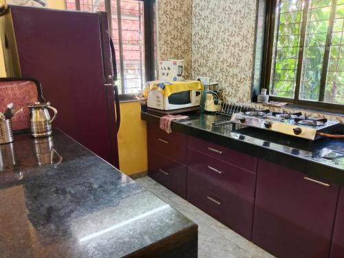 a kitchen with a counter top with a microwave at Fulora Guesthouse in Dapoli