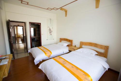 twee bedden in een kamer met een kamer met bij Han Shu Xiang Yuan Hostel in Jianshui