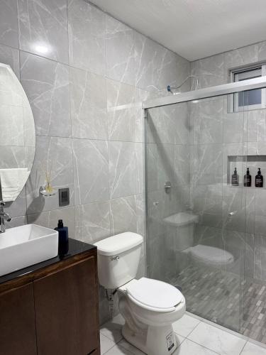a bathroom with a shower and a toilet and a sink at Belisario Apartment in Ocotlán