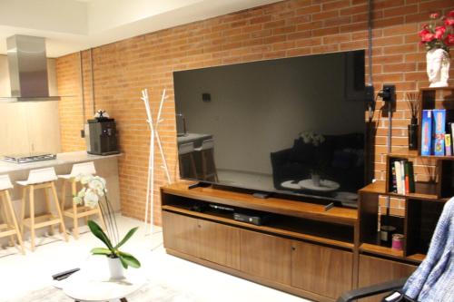 a living room with a large television on a brick wall at New apartment in Yu Country GDL view 22nd floor in Guadalajara