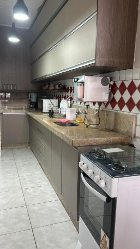 a kitchen with a stove and a counter top at Loft J&C 01 in Primavera do Leste