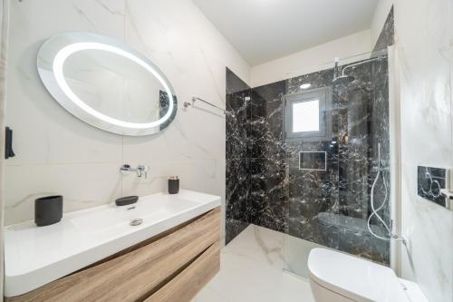 a bathroom with a white sink and a mirror at Villa La Bianca in Marketáta
