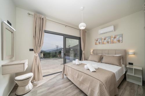 a bedroom with a large bed and a balcony at Villa La Bianca in Marketáta