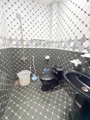 a bathroom with a black toilet and a sink at Serene Elegance Hotel in Islamabad