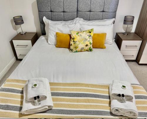 a bedroom with a large bed with towels on it at Quiet 2 Bedroom Apartment in Headington, Close to Oxford Hospitals & Brookes University in Oxford