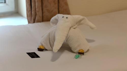 a stuffed elephant is sitting on a bed at The Waverley Guest House in Inverness