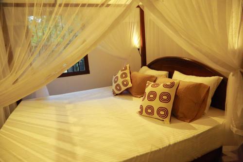 a bedroom with a bed with white sheets and pillows at Muraaya in Habaraduwa Central