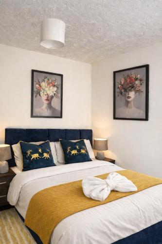 a bedroom with two beds and two pictures on the wall at Large 4 bedroom house for Contractors, Large groups or Retreat sleeps 8 people in Durham - NO Smoking Indoor House in Edmondsley