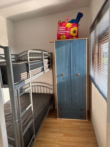a bunk room with a bunk bed and a blue cabinet at g11 chalet in Mablethorpe