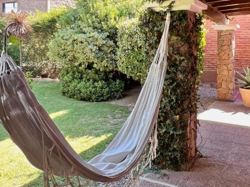 a hammock hanging in a garden next to a building at Refugio - Suite privada con jardín y parrilla en Chilecito in Chilecito