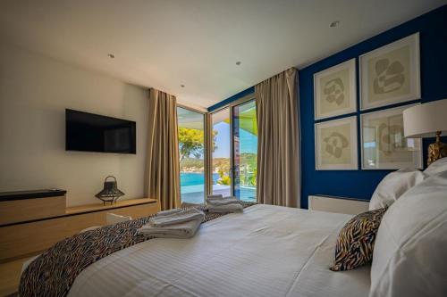 a bedroom with a large bed with a view of the ocean at Luxury Seafront Villa Aman Korcula with Pool in Korčula