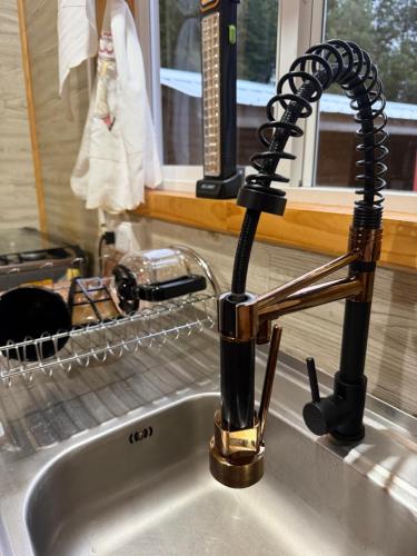 a kitchen sink with a black faucet at Cabaña A & M in Chaitén