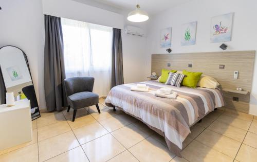a bedroom with a large bed and a chair at Casa Sol - Bright 3BR Steps from the Beach & Shops in Limassol
