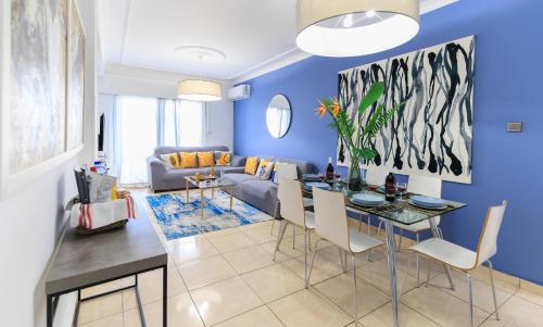 a blue living room with a table and a couch at Casa Sol - Bright 3BR Steps from the Beach & Shops in Limassol