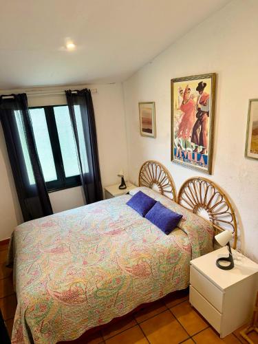 a bedroom with a king sized bed with blue pillows at Cortijo Majada de las Vacas in Santa Olalla del Cala