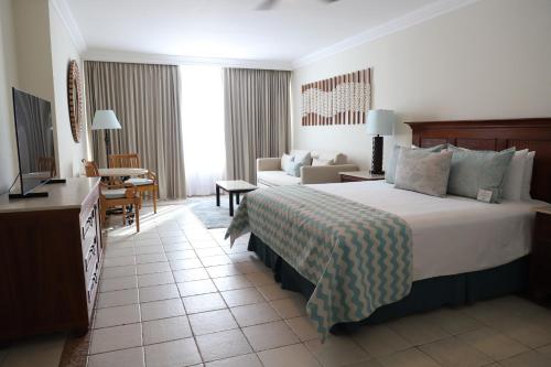 a hotel room with a bed and a living room at Pierre Mundo Imperial Riviera Diamante Acapulco All Inclusive in Acapulco