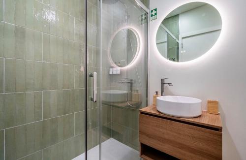 a bathroom with a sink and a shower with a mirror at Brisa do Mar in Quarteira