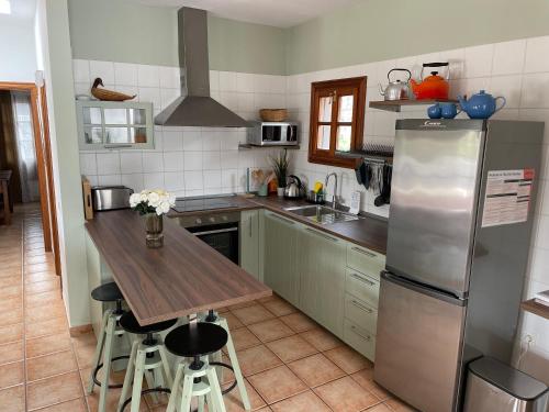 a kitchen with a stainless steel refrigerator and a wooden table at Villa Pola Marinas Playa B in Playa Blanca