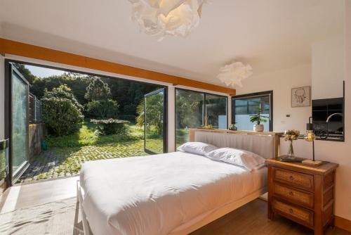 a bedroom with a bed and a large window at Azores Green Woods Villa in São Vicente Ferreira