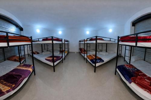 a room with four bunk beds in it at The rest point dormitory in Khātu