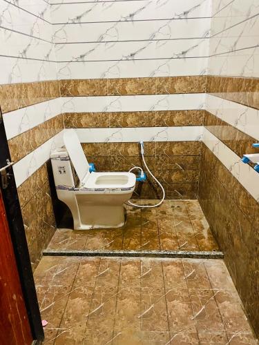 a bathroom with a toilet in a tiled room at The rest point dormitory in Khātu