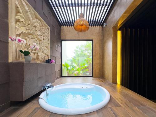 a bath tub in a bathroom with a large window at Depari Dago Villa in Bandung