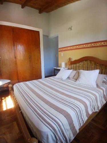 a bedroom with a large bed with a wooden headboard at Departamento Independiente con Terraza in La Cieneguita