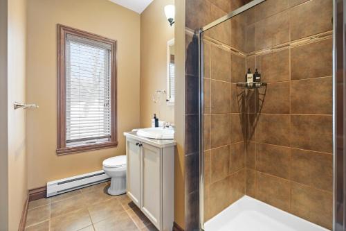 a bathroom with a shower and a sink and a toilet at Townhouse On The Golf La Bte -10min To Tremblant in Mont-Tremblant