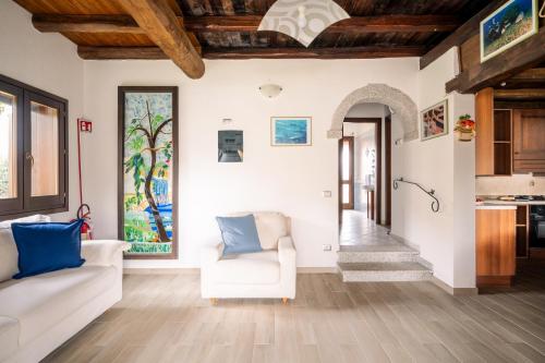 a living room with a white couch and blue pillows at Case Peschiera 17 in Nuragheddu