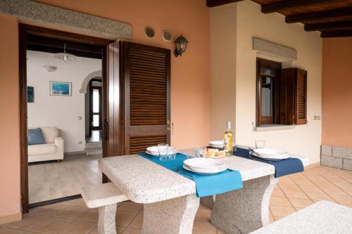 a dining room with a blue table and chairs at Case Peschiera 17 in Nuragheddu