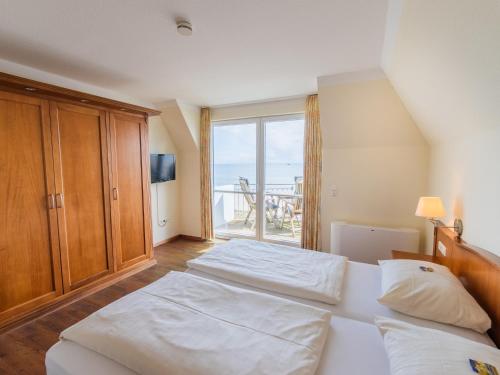 a bedroom with a large bed and a large window at Hof Sierksdorf in Sierksdorf