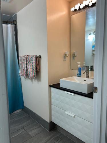 a bathroom with a sink and a mirror at Single, Double or Quad Oceanview Studios - Direct Beach Access, Oceanfront Pool & Tiki in Daytona Beach Shores