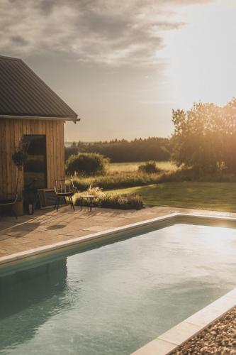 ein Swimmingpool vor einem Haus mit Terrasse in der Unterkunft Osada Augustów in Mirsk