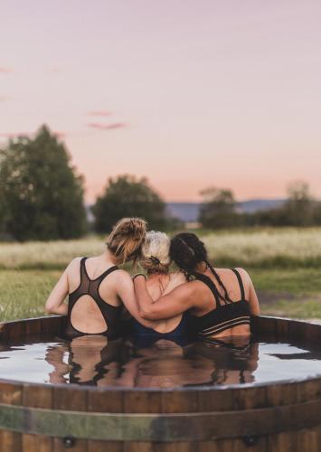 Drei Frauen in Badeanzügen sitzen in einem Whirlpool in der Unterkunft Osada Augustów in Mirsk