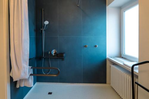 a bathroom with a shower with blue walls and a window at Il Platano Guest House in Quartino