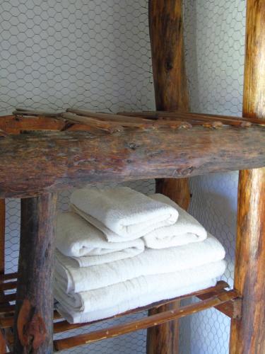 a stack of white towels on a wooden shelf at Iberá Porá in Colonia Carlos Pellegrini