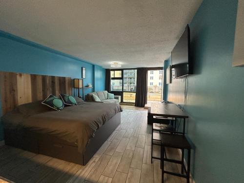 a bedroom with a bed and a blue wall at Single, Double or Quad Oceanview Studios - Direct Beach Access, Oceanfront Pool & Tiki in Daytona Beach Shores