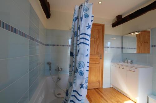 a bathroom with a shower curtain and a sink at Chez soule in Riupeyrous