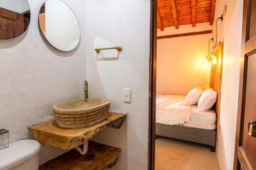 a bathroom with a sink and a bed at Condominio The monkey House in Villa de Leyva