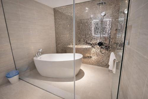 a bathroom with a tub and a glass shower at klcc Star residence Kuala Lumpur in Kuala Lumpur
