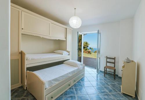 a bedroom with two bunk beds and a chair at Casa del passero - Villa with Infinity Garden and Sea View in Forio d'Ischia