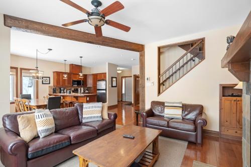 a living room with leather furniture and a ceiling fan at House On The Golf La Bte -10min To Tremblant 150 in Mont-Tremblant