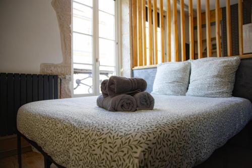 a pile of towels sitting on top of a bed at Le Millésime in Dijon