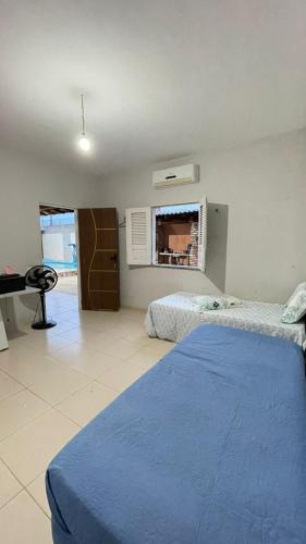a bedroom with two beds and a window and a piano at Casa Parnaíba in Parnaíba